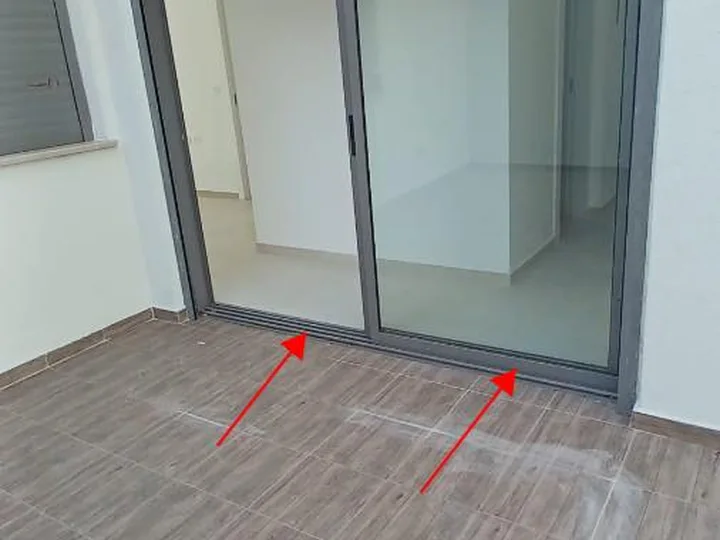 איטום חלון לקוי: חוסר איטום בין מסילת הוויטרינה לרצפה.